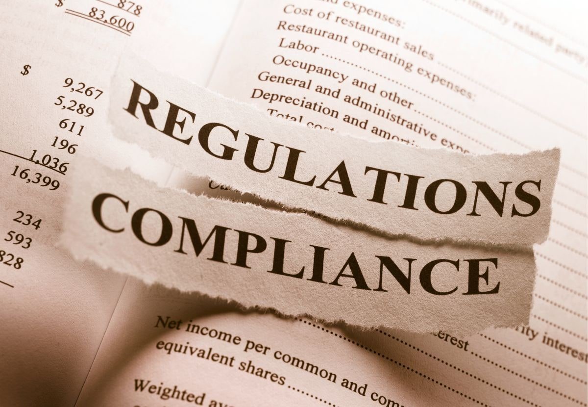 Torn newspaper headlines reading Regulations and Compliance over financial documents