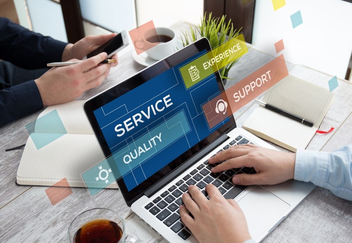 Laptop screen showing service, quality, experience, and support icons